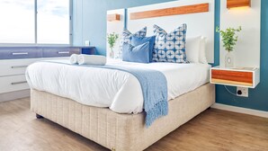 Une chambre à coucher moderne avec un grand lit, une table de chevet, une commode et une fenêtre.