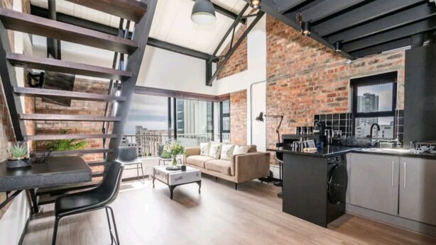 Um apartamento moderno do tipo loft, com cozinha, sala de jantar e área de estar.