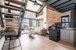 Egy modern, nyitott alaprajzú lakás, amelyben konyha, étkező és nappali található.