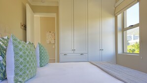 Une chambre à coucher avec un lit, une armoire et une fenêtre.
