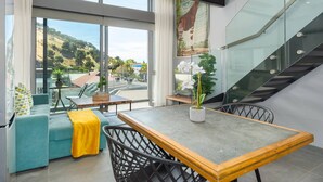 Une pièce moderne comprenant un canapé, une table à manger et un escalier.