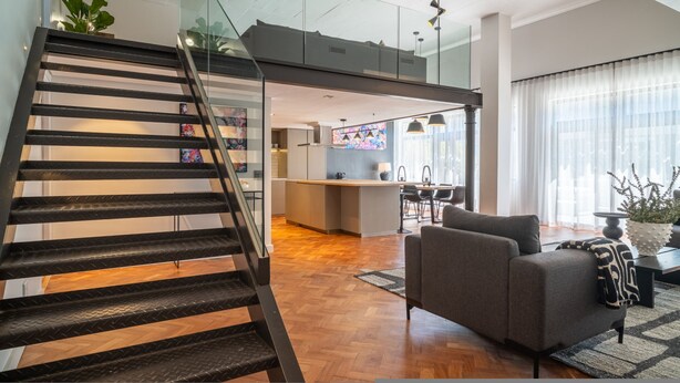 A modern interior with a staircase, a kitchen area, and a seating area. - Two Bed Designer Luxury Central De Waterkant (Cape Town)