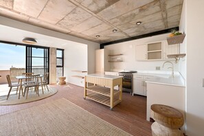 Una cucina moderna con mobili bianchi, un tavolo di legno e un'ampia finestra con vista panoramica.
