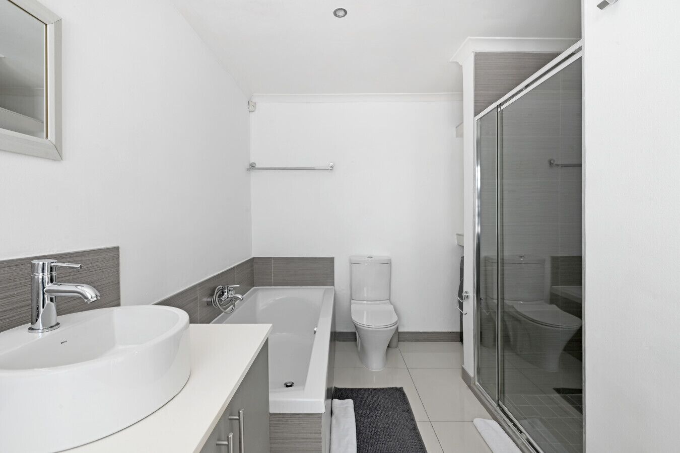 A modern bathroom with a bathtub, a toilet, and a shower area.