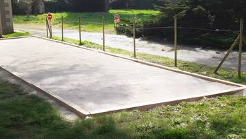 Una piattaforma in cemento con un segnale di divieto di accesso, circondata da vegetazione e zona residenziale.