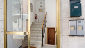 Un escalier menant à une porte, un extincteur et une boîte aux lettres fixée au mur.