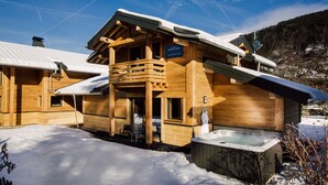 Uma cabana de madeira com hidromassagem e uma placa indicando ser o Chiemsee Resort.