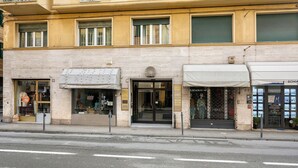 Un immeuble doté de plusieurs devantures de magasins, avec une entrée bien visible, une porte en verre et une enseigne au-dessus.