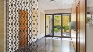A hallway with a patterned metal partition, a wooden door, and a view of the outside. - Apartment 'Lally's Nest' with Private Terrace, Wi-Fi and Air Conditioning (Rapallo)