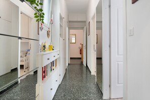 A hallway with a white door, a mirror, and a plant. - Apartment 'Gaia' with Wi-Fi and Air Conditioning (Rapallo)