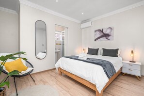 A bedroom with a bed, bedside table, mirror, and a chair. - Winelands Getaway (Stellenbosch)