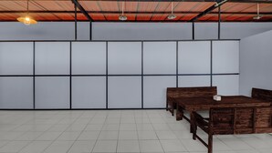 A room with a tiled floor, a wooden desk with drawers, a bench, and a hanging light fixture. - Hotel O near Trans Studio Theme Park formerly Sunset Cozy (Kuta)