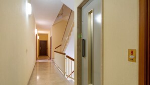 A hotel hallway with a marble floor, a staircase, and a door with a number sign. - Apartment 'Solaria' with Balcony, Wi-Fi and Air Conditioning (Rapallo)