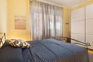 Ein Schlafzimmer mit einem Bett, einem Kissen, einem Vorhang und einem Kleiderschrank.