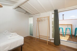 A bedroom with a bed, a drying rack, and a view of the outside. - San Frediano Designer Duplex (Firenze)