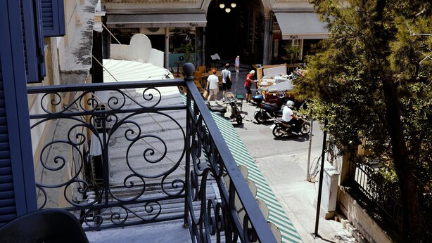 A building with a tiled roof, a sign reading "SPA", and a balcony with a wrought iron railing. - Luxurious Loft in Monastiraki (Athens)