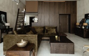 A modern living room with a sofa, coffee table, and a wooden side table with a bowl. - Luxurious Loft in Monastiraki (Athens)