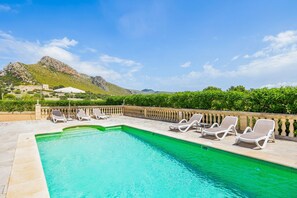 A swimming pool with lounge chairs, a stone deck, and a mountainous backdrop. - Holiday Home 'Margarita' with Mountain View, Wi-Fi and Air Conditioning (Illes Balears)
