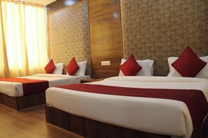 A hotel room with two beds, each with red and white bedding, and a wooden headboard. - Hotel Black Diamond (Zirakpur)
