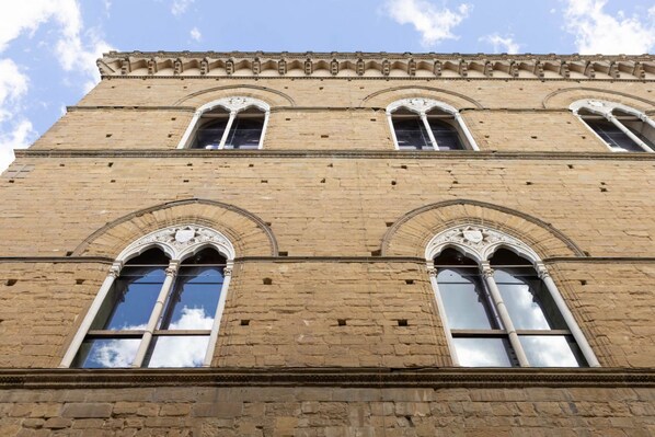 A tall, historic building with arched windows and a flat roof. - Orsanmichele Suite - Florence (Firenze)