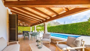 An outdoor patio with a pool, wooden furniture, and a view of the mountains. - Holiday Home 'Villa Cal Peso' with Mountain View, Wi-Fi and Air Conditioning (Illes Balears)