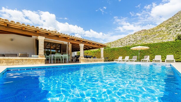 A swimming pool with lounge chairs and a covered patio area. - Holiday Home 'Villa Cal Peso' with Mountain View, Wi-Fi and Air Conditioning (Illes Balears)