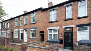 A row of terraced houses with brick facades, white-framed windows, and black doors. - Cosy 4 Bed Townhouse Near Keele University and Royal Stoke Hospital (Newcastle-Under-Lyme)