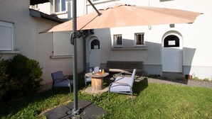 An outdoor seating area with a table, chairs, and a large umbrella. - Mirabelle Room with Wi-Fi (Brû)