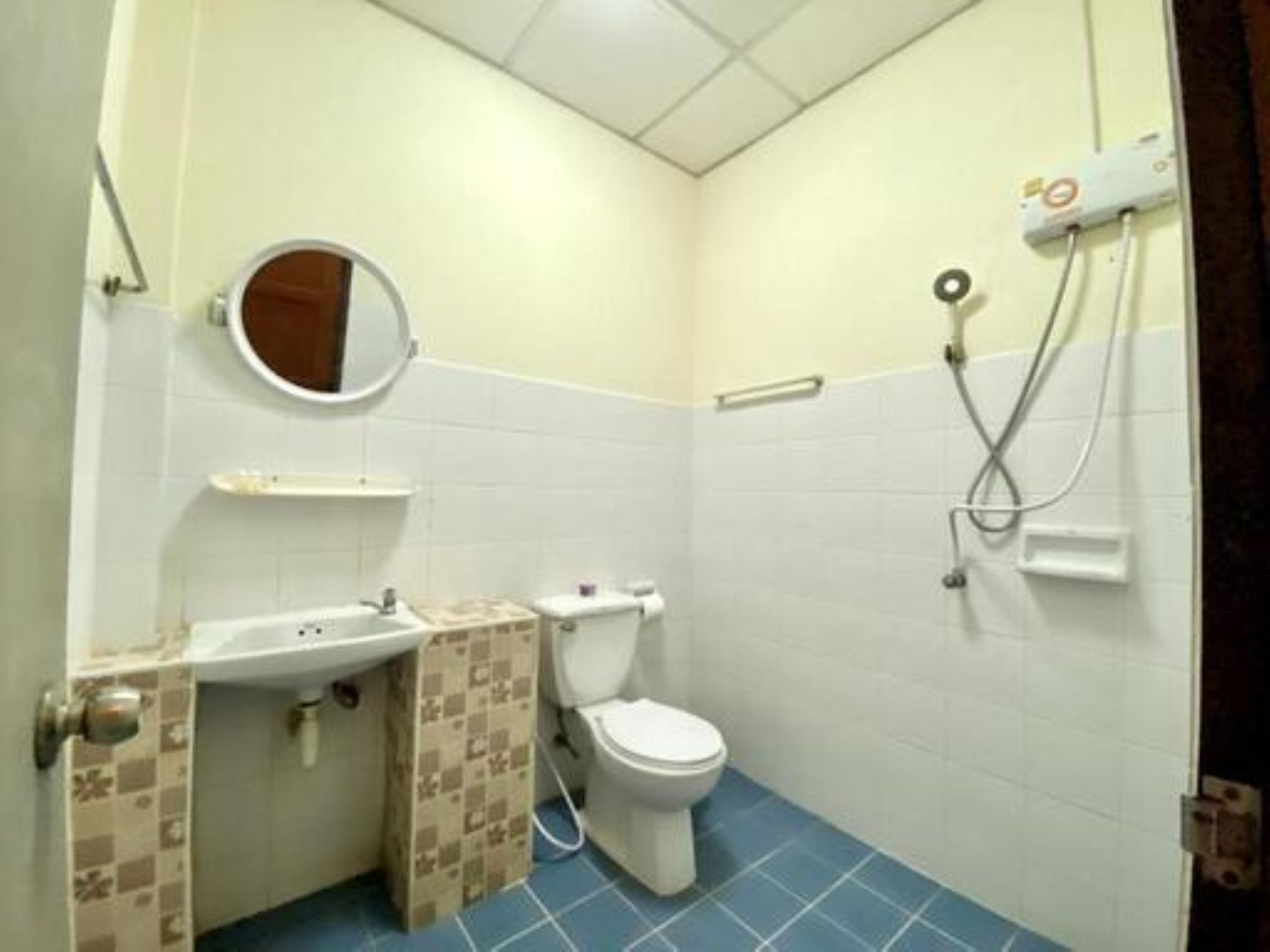 Een kleine badkamer met toilet, wastafel en douche.