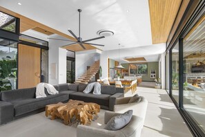 A modern living room with a sectional sofa, a coffee table, and a dining area with chairs and a table. - Vaquero Del Mar (La Dulce Vida, Hacienda Pinilla)