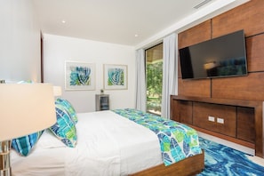 Ein Hotelzimmer mit einem Bett, einem an der Wand befestigten Fernseher und Bildern an der Wand.
