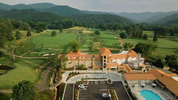 A golf course with a clubhouse and swimming pool. - Golf Course View + Pool. Fitness Center. Dining. (Waynesville)