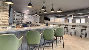 A bar area with a long counter, green bar stools, and pendant lighting. - Golf Course View + Pool. Fitness Center. Dining. (Waynesville)