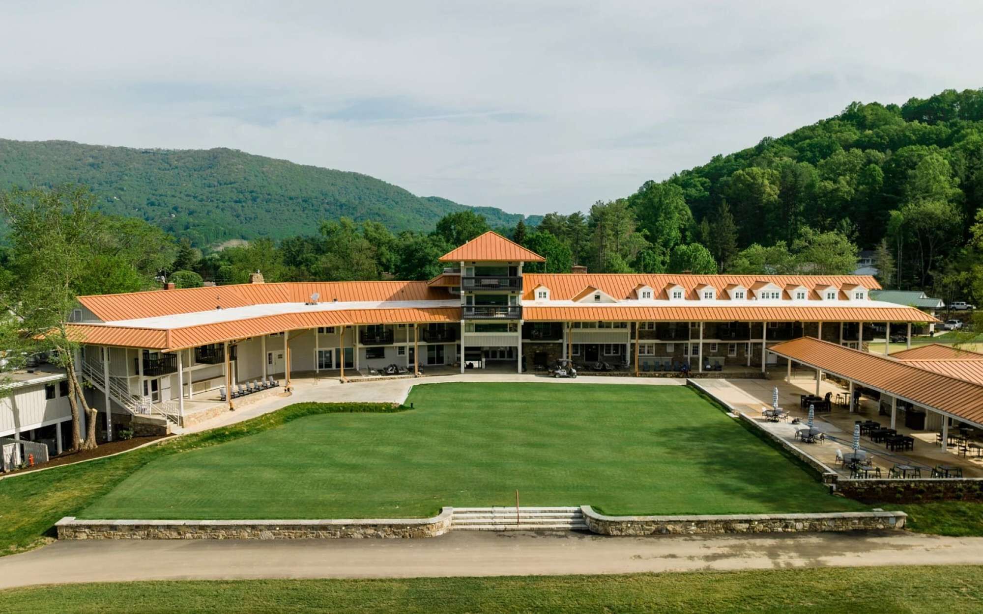A large, multi-story building with a central courtyard and a mountain backdrop.