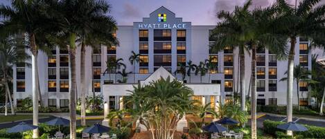 Un hôtel Hyatt Place doté d’une façade symétrique, de palmiers et d’espaces de détente en plein air.