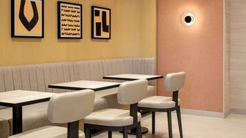 A restaurant interior with a booth seating area, tables, and chairs.
