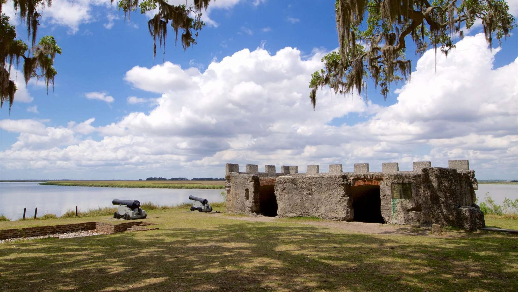 Un fort historique, doté de canons, entouré d’eau et d’arbres.