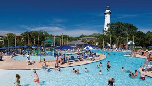 A large outdoor swimming pool with multiple lanes, surrounded by lounge chairs and umbrellas. - Direct Golf Course Access + Pool. Dining. Shuttle. (St. Simons Island)
