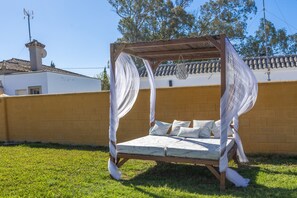 A bed with a canopy in an outdoor setting.