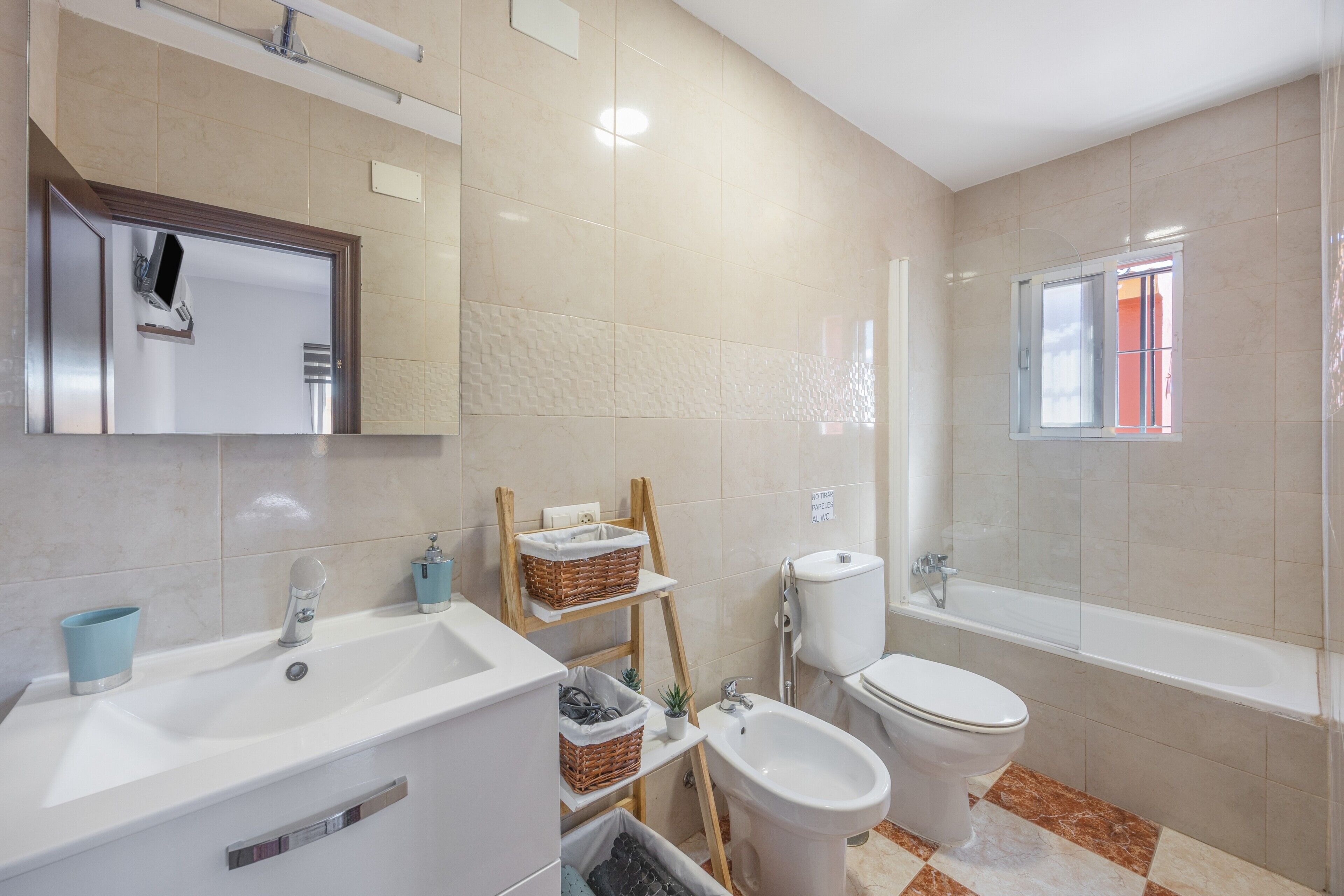 A modern bathroom with a sink, bidet, toilet, and bathtub.