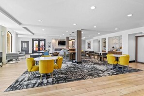 A hotel lobby with a central seating area, a bar, and a television screen. - Walk to Santa Cruz Beach | Free Breakfast + Pool (Santa Cruz)