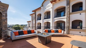 A multi-story building with a courtyard featuring outdoor seating and a fire pit.