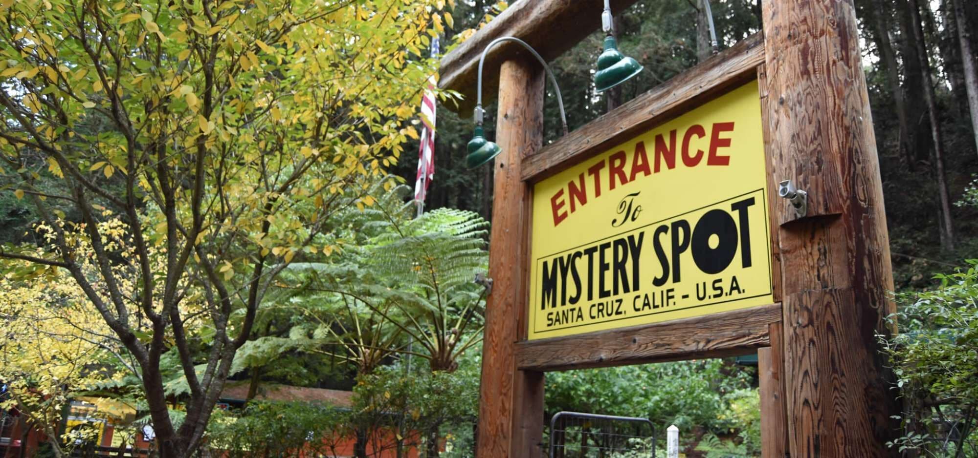 Un letrero de madera con el texto 'Entrance to Mystery Spot Santa Cruz, Calif. U.S.A.'