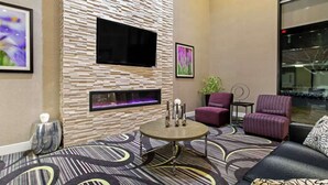 Un salon moderne doté d’un téléviseur à écran plat, d’une cheminée et de sièges confortables.