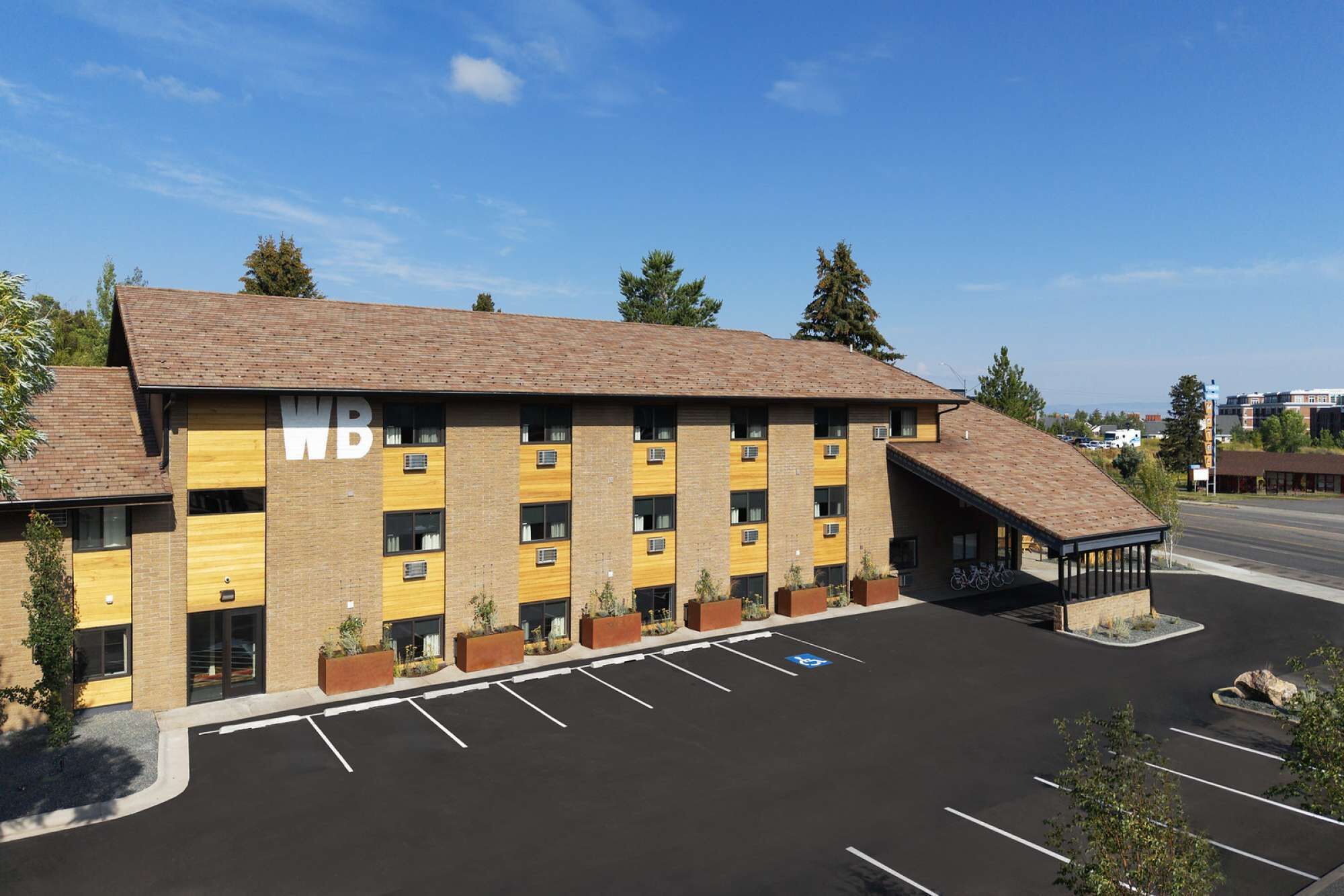 A multi-story hotel with a parking lot in front.
