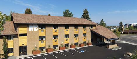 A multi-story hotel with a parking lot in front.