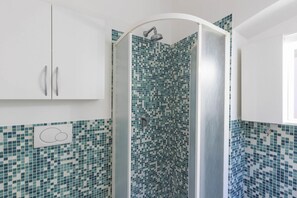 A bathroom with a shower enclosure, tiled walls, and a white cabinet. - Santa Maria Novella Comfort (Firenze)