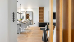 Eine moderne Küche mit Essbereich, Holzböden und einem kleinen Tisch mit Gläsern.