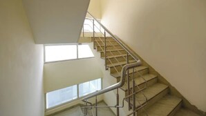 A staircase with metal railings and a view of the sky through a window. - Hotel Lakshmi Palace (New Delhi)