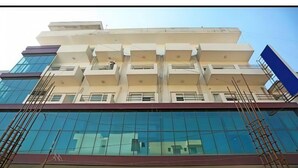 A multi-story building with a modern architectural design, featuring large glass windows and a flat roof. - Hotel Lakshmi Palace (New Delhi)